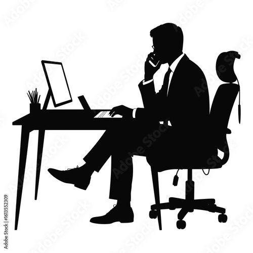 Silhouette of a businessman working at a desk on his laptop and talking on the phone
