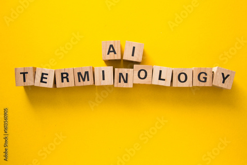 Wooden cubes showing ai terminology on yellow background