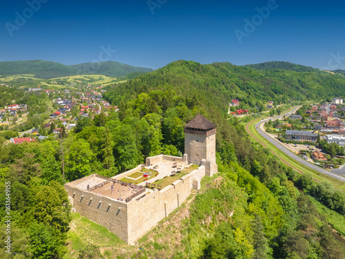 Fototapeta Naklejka Na Ścianę i Meble -  Lot nad Muszyną z Zamkiem Baszta na głównym planie w piękny, wiosenny dzień.