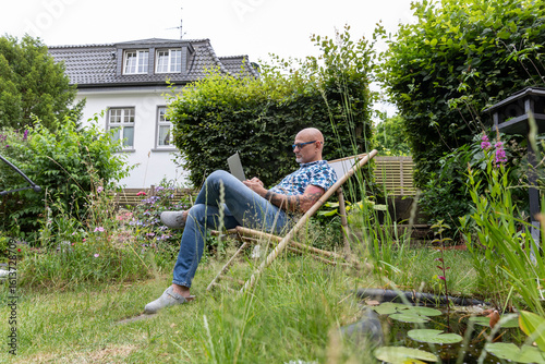 Freelancer working on laptop in garden