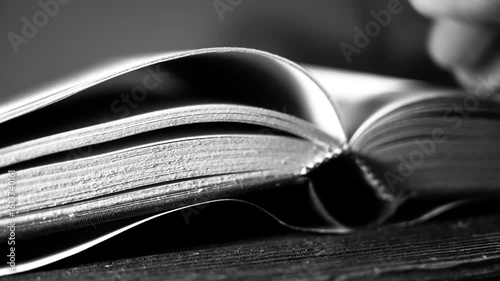 Monochrome footage, caucasian man turning old book pages searching for knowledge, information.