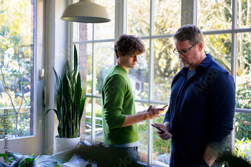 at home, father, son, family, together, generations, using a mobile phone, communication, give advice, smartphone, not talking, speechless