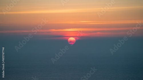 Sun setting over hazy ocean horizon sunset