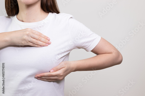 Wallpaper Mural Woman performing breast self-exam, checking for any lumps or changes. Concept of cancer prevention, breast cancer awareness, breast check. Torontodigital.ca