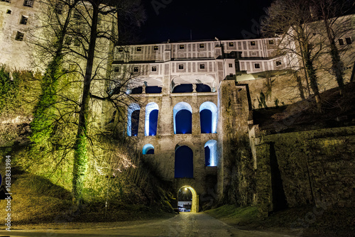 Foto Night view of Cesky Krumlov castle stone archway illuminated by lights