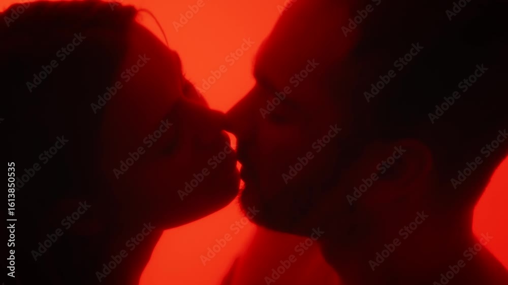 Silhouetted Couple Kissing Behind a Red Glass Surface