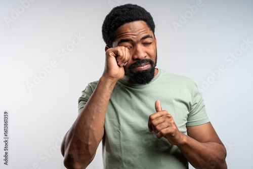 Foto Black man rubbing eyes with discomfort, irritated and tired, experiencing eye itching and burning, eye health concept