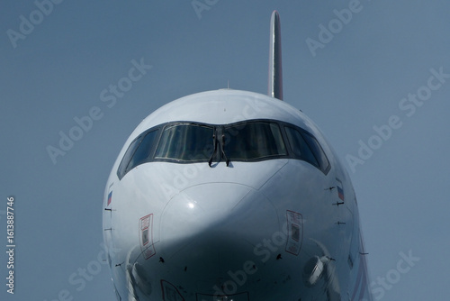 Fotografi Airplane Nose Close-Up with Cockpit Windows, Close up view of the front of a passenger jet airplane