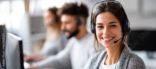 Close-up of a smiling female call center staff wearing a headset and working at a computer in a bright office, ideal for customer support, service, or corporate communication themes