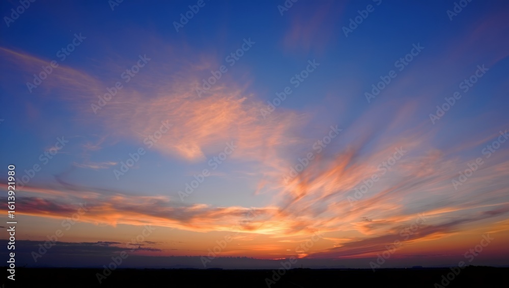 Obraz premium Dramatic sunset sky with fiery clouds and deep blue hues
