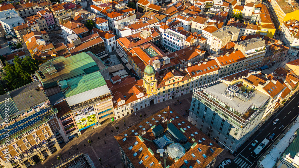 Naklejka premium Rijeka city center and waterfront aerial view at sunset, panoramic view of the Kvarner Gulf in Croatia. Scenic harbor with boats, historic architecture, container terminal, canals, seafront promenade