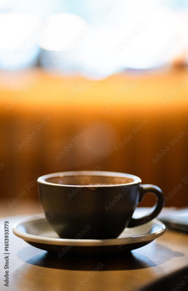 Obraz premium Side view of hot latte coffee a black cup on wooden table.