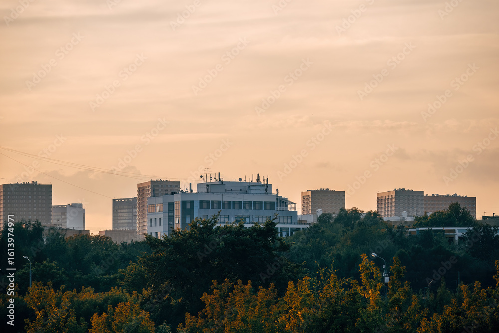 Fototapeta premium Moscow cityscape with trees in park and buildings during sunset sky