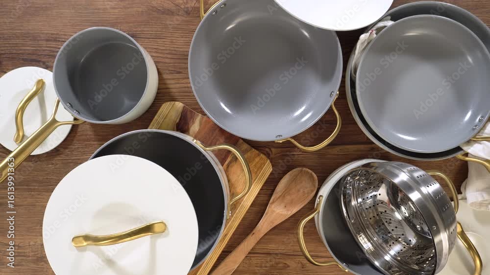 Hands closing white lid over nested cookware set
