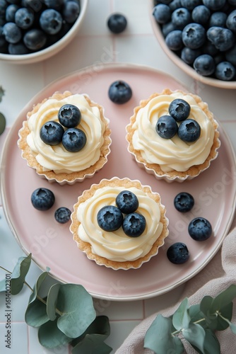 Blueberry Tarts Decorated With Cream and Fresh Berries on a Pink Plate in a C...