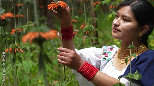 Indigenous woman smelling orange flower in slow motion