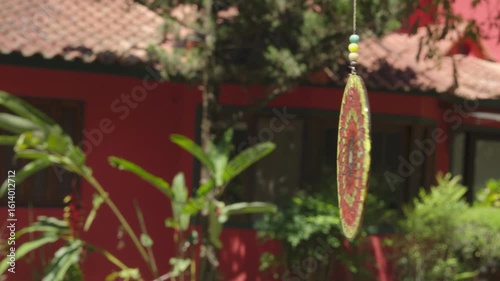 Glass wind chime art piece blowing in the wind in tropical landscape