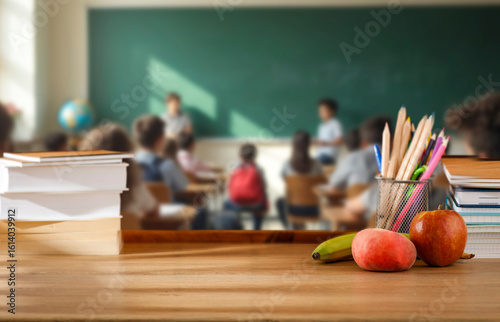 Photography School desk with books and supplies, blurred students and teacher in classroom background