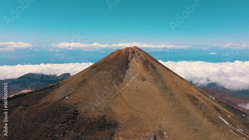 Aerial view of Mount Teide and surrounding lava flows above sea of clouds at sunset in Teide National Park, Tenerife