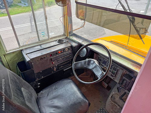 The interior view of a cab of an old school bus from the 80s