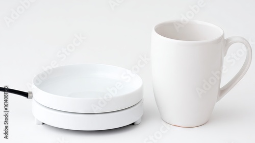 White ceramic mug placed beside a sleek electric cup warmer on a clean surface, showcasing modern kitchen technology and minimalistic design for beverage enthusiasts
