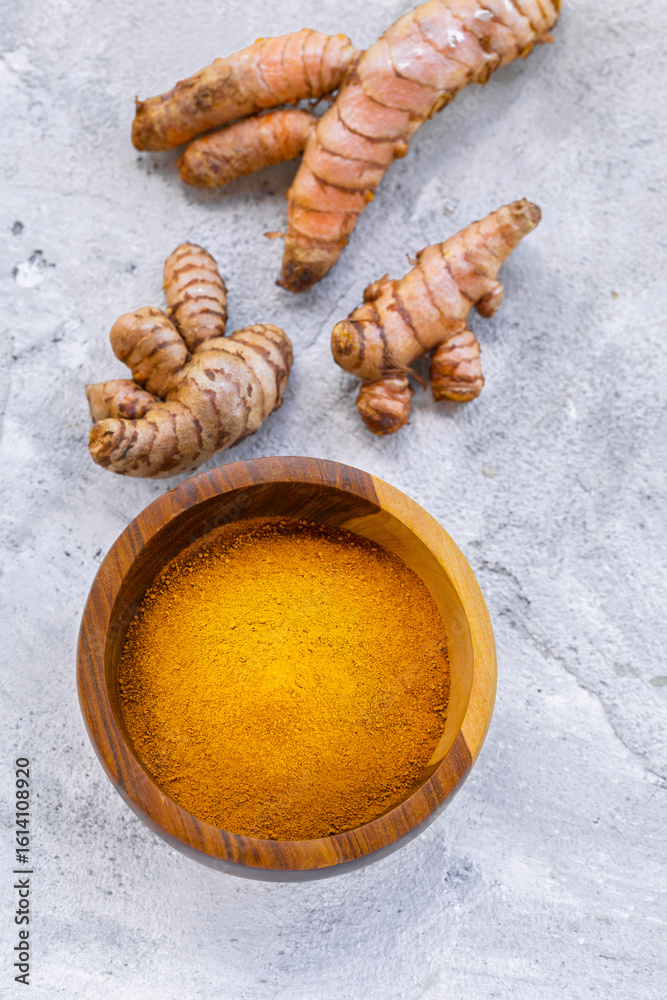 Fototapeta premium Fresh and Ground Turmeric on Rustic Background – Natural Health and Culinary Ingredient