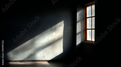 Shadow cast from a window falling across a dark gray interior wall