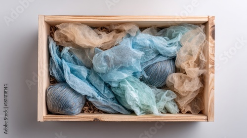 Wooden crate filled with packing material shown from top view on light backdrop