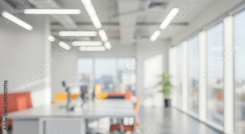 Blurred modern office interior with large windows and bright daylight. Abstract business background concept.