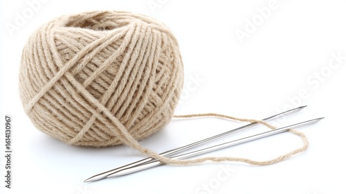 Ball of beige yarn with two silver knitting needles resting beside it, showcasing the art of knitting and the cozy atmosphere of crafting and creativity