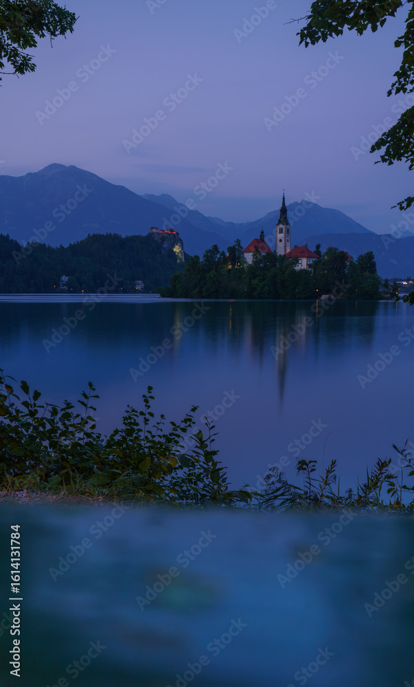 Obraz premium Peaceful twilight over Lake Bled with island church and mountain reflections