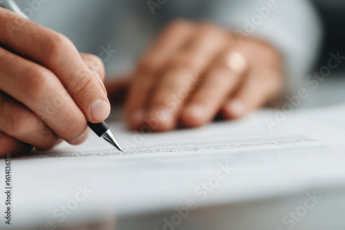 in modern creative office two individuals are dynamically interacting as they sign contractual agreement