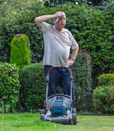 man hot and tired cutting the grass