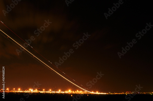 Airplane Taking Off at Night with Long Exposure Creating a Long Light Trail