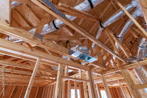 New residential construction showcases wooden beams ductwork being installed in new home setting.