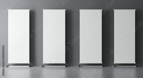 Four identical white roll-up banners with sleek bases against a muted gray wall, creating a minimalist and professional atmosphere.