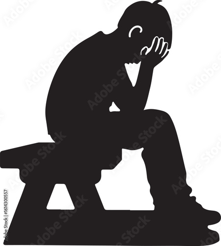 Silhouette of a boy sitting with head in hands despair