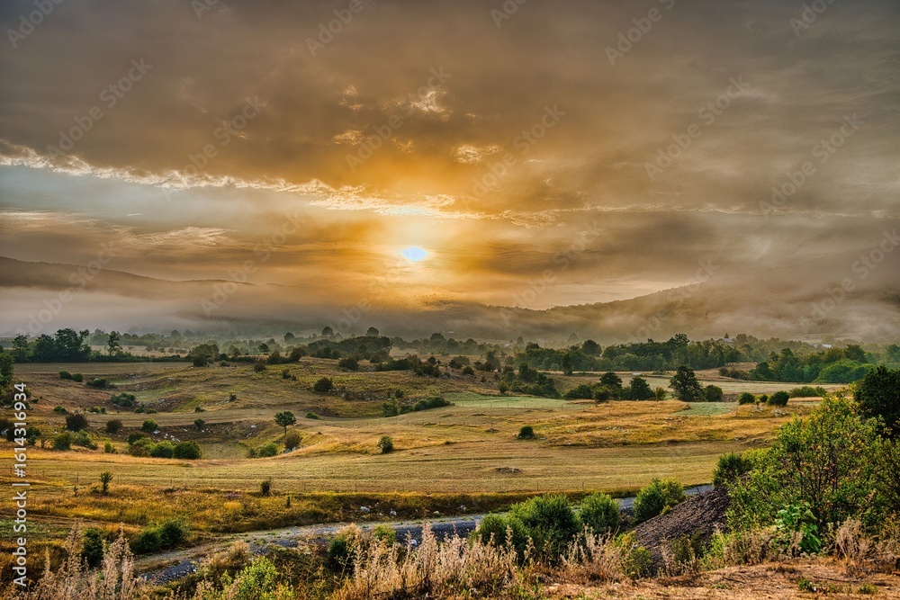 Fototapeta premium Sunrise over a serene rural landscape.
