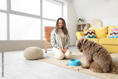 Young woman feeding cute po...