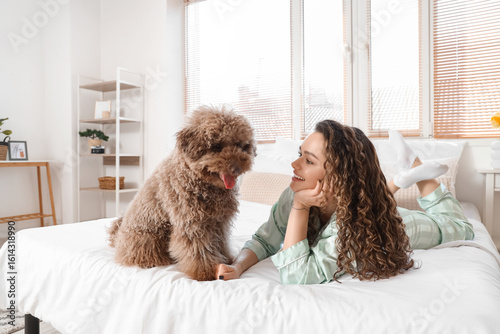 Young woman with poodle lyi...