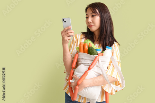 Young Asian woman with mobi...