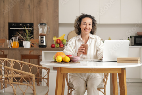 Mature woman with glass of ...
