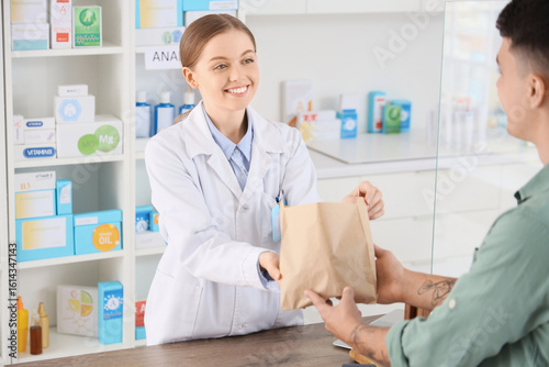 Female pharmacist giving or...