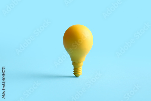 Yellow light bulb on blue b...