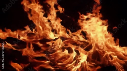 Close up view of intense orange and yellow flames rising against a dark black background