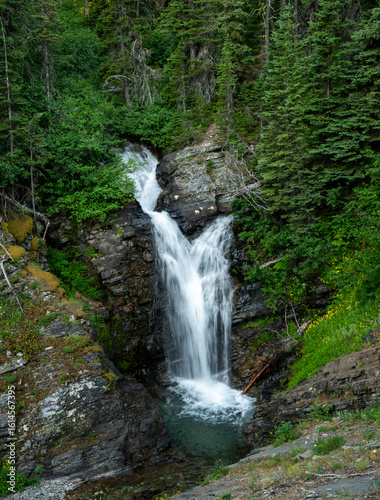 Water Fall Rushes Through The Valley Along The Falls Creek In Glacier