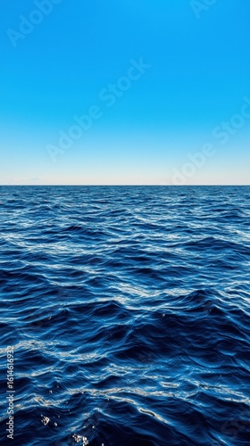 Calm Ocean Waves Under Clear Blue Sky with Gentle Horizon at Dusk