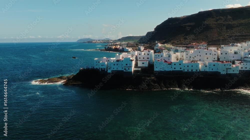 Aerial: Atlantic Ocean with blue color and white neighborhood during the day in Gran Canaria, Spain, pan drone shot Aerial: Atlantic Ocean with blue color and white neighborhood during the day in Gran Canaria, Spain, pan drone shot