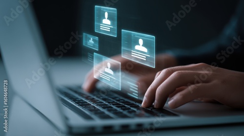 Hands typing on a laptop keyboard with glowing digital profile icons appearing on a futuristic interface