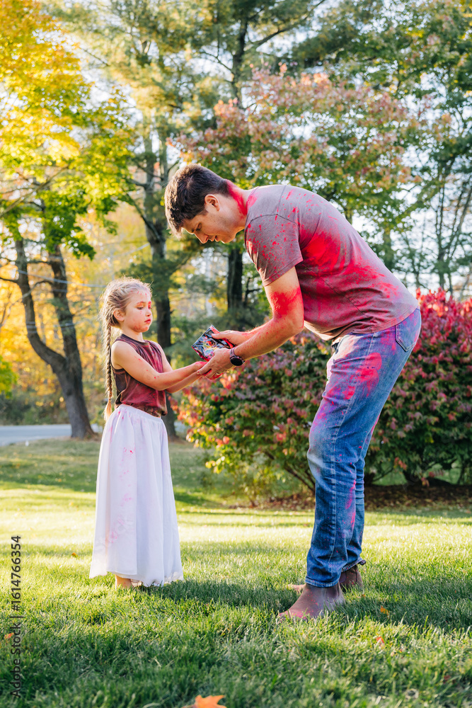 Fototapeta premium Father and daughter exchanging colorful powders